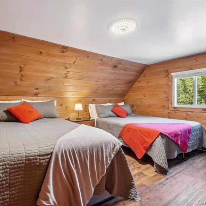 Bedroom 2 upstairs, with 2 queen beds, views of the courtyard and forest. 