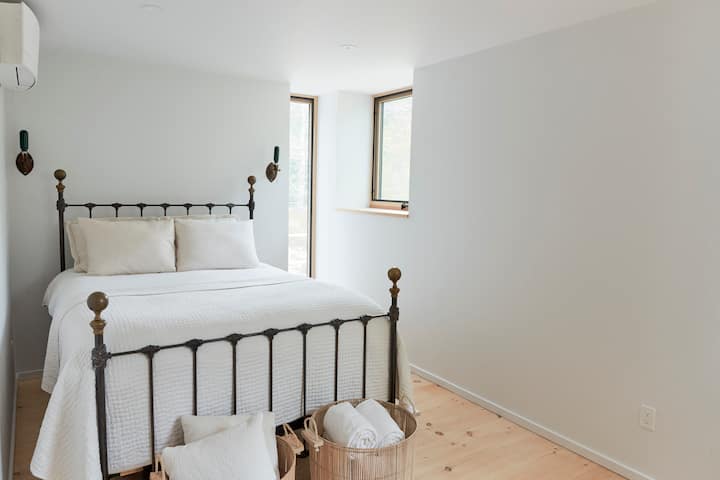 Primary bedroom with queen bed, three windows, A/C & Heat