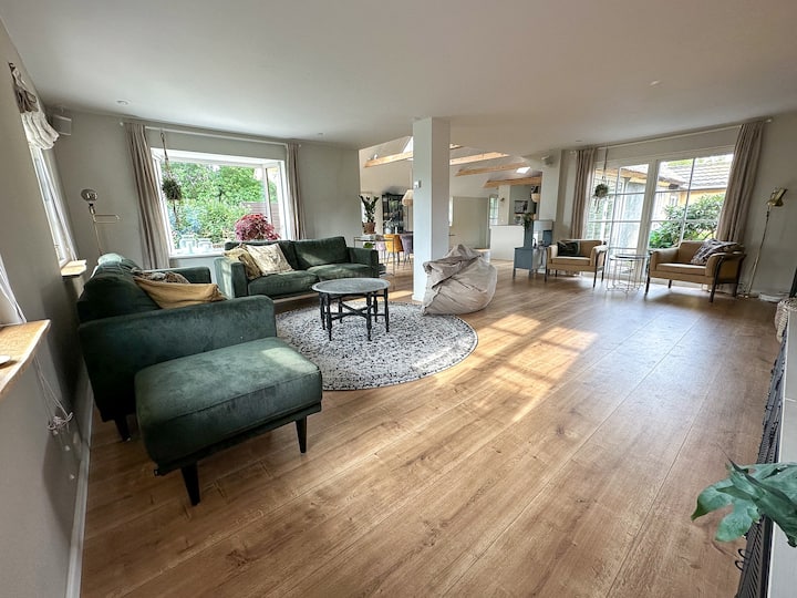 Großer TV-Bereich mit Sofa, Fatboy-Säcken Kissen und Sesseln in einem Lesebereich