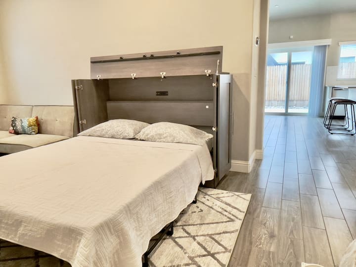 Додека влегувате, лево е дополнителната дневна соба/канцелариски простор. Поставете удобен брачен кревет „Марфи“ и модерен декор.  (Брачниот кревет „Марфи“ е поставен како опција за трет кревет).