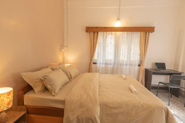 2nd Bedroom with Kind-sized bed, work space, garden view and shared bathroom. 