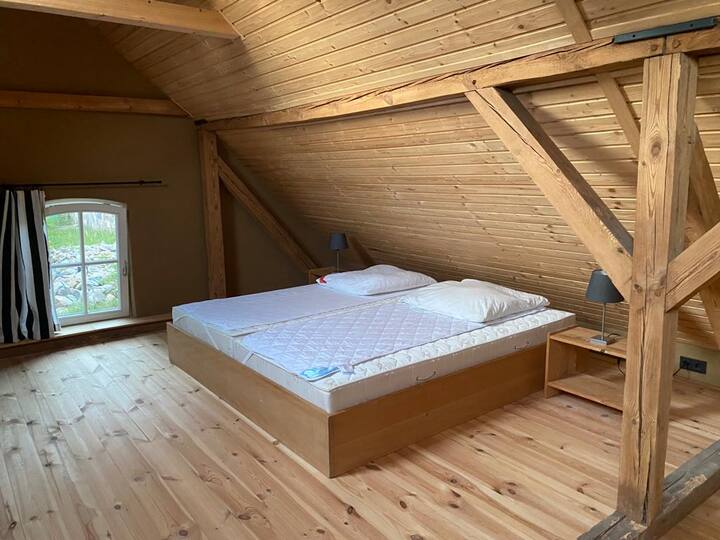 Спалнята на горния етаж е много голяма и светла . Има 2 големи капандури и страничен прозорец.