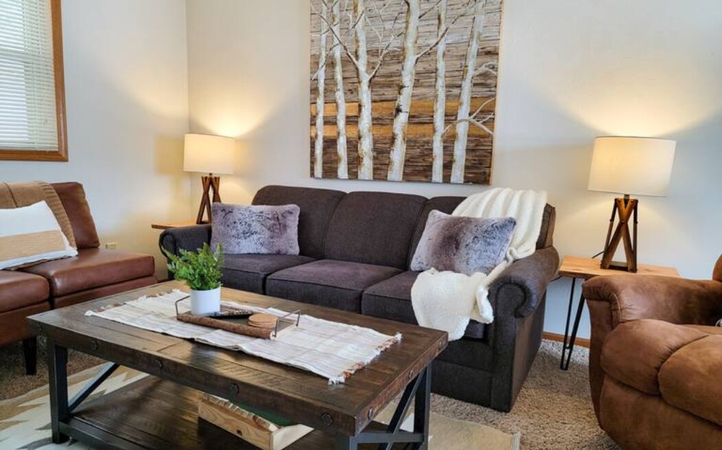 Mobilie të rehatshme të dhomës së ndenjjes me divan gjumi për një ose dy vizitorë shtesë, mbështetëse, ventilator tavani dhe televizor inteligjent 42", në mënyrë që të mund të hysh në shërbimet e tua të preferuara të transmetimit