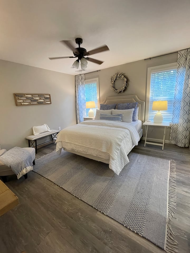 غرفة نوم أساسية مع منطقة جلوس وحمام خاص وخزانة ملابس كبيرة