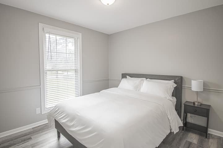 راحة هادئة في غرفة نومنا التي تضم سرير كوين – استرخ في احتضان سريرنا المريح. يتم تعزيز الأجواء المهدئة من خلال التوهج اللطيف للمصباح بجانب السرير، مما يخلق زاوية مثالية للاسترخاء. راحتك، أولويتنا.