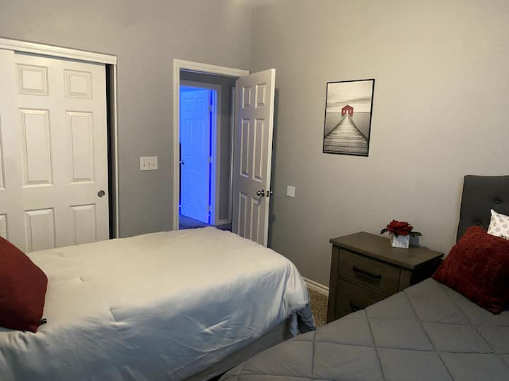 Esta habitación incluye una cama doble larga y de tamaño normal.  Las 2 mesas de noche incluyen un cargador de teléfono y enchufes eléctricos.  