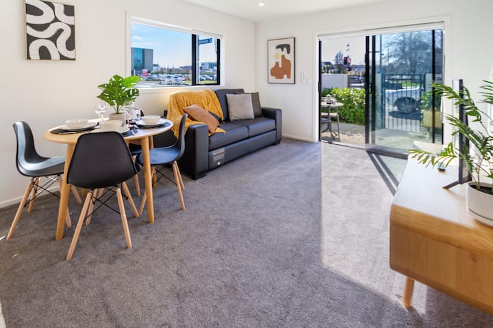 พื้นที่รับประทานอาหารและพื้นที่นั่งเล่นแบบเปิดโล่งที่เปิดออกสู่ลานที่ใกล้ชิด