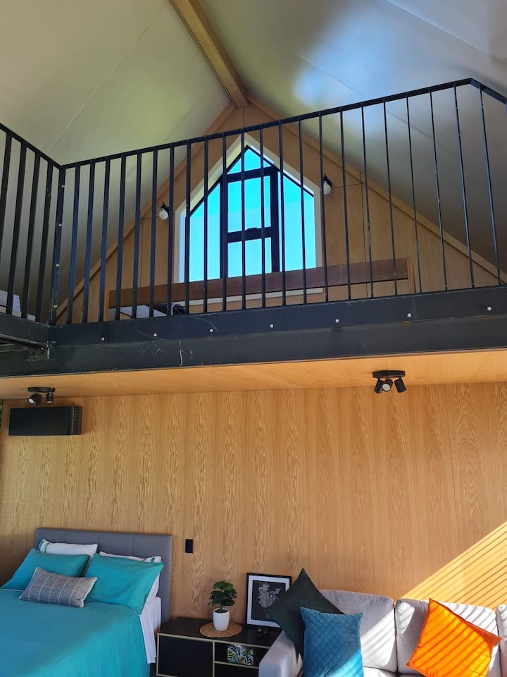 Open plan living  space, Double loft bed above, accessed by a ladder.