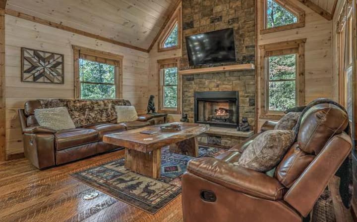 تحتوي الغرفة العائلية في الطابق الرئيسي على أريكتين جلديتين مستلقيتين ومدفأة تعمل بالغاز وتلفزيون ذكي كبير.
