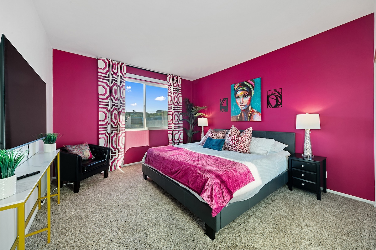 
Ingia kwenye chumba cha kulala chenye utulivu na kitanda cha plush kilicho na taa za pembeni zenye joto. Picha ya kifahari juu ya kitanda inaongeza sifa, wakati televisheni maridadi na viti vya starehe vinaunda sehemu ya kupumzika. Sehemu hii inavutia, inasawazisha mtindo na starehe kikamilifu