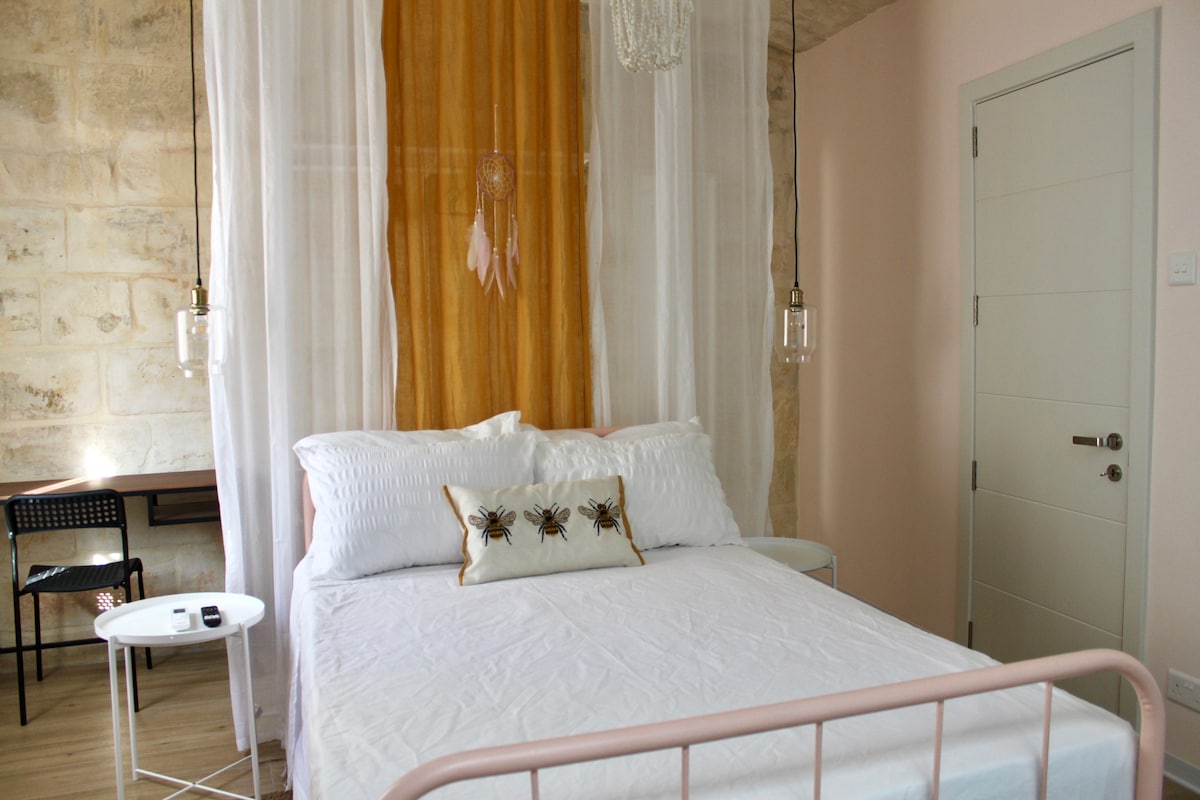 Slatka ružičasta soba s radnim stolom, prostranim ormarom i malim vanjskim prostorom.