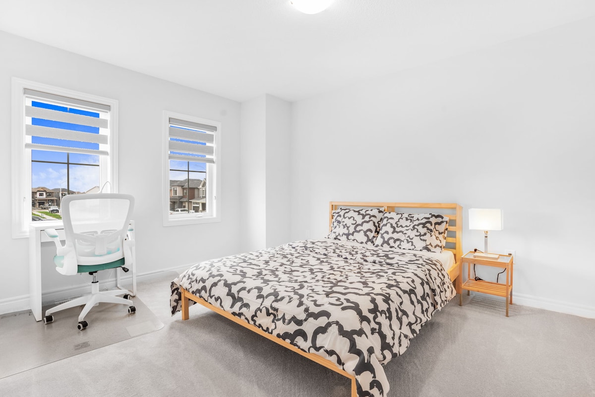 Dormitorio con cama tamaño queen size y espacio de trabajo exclusivo y vestidor. 