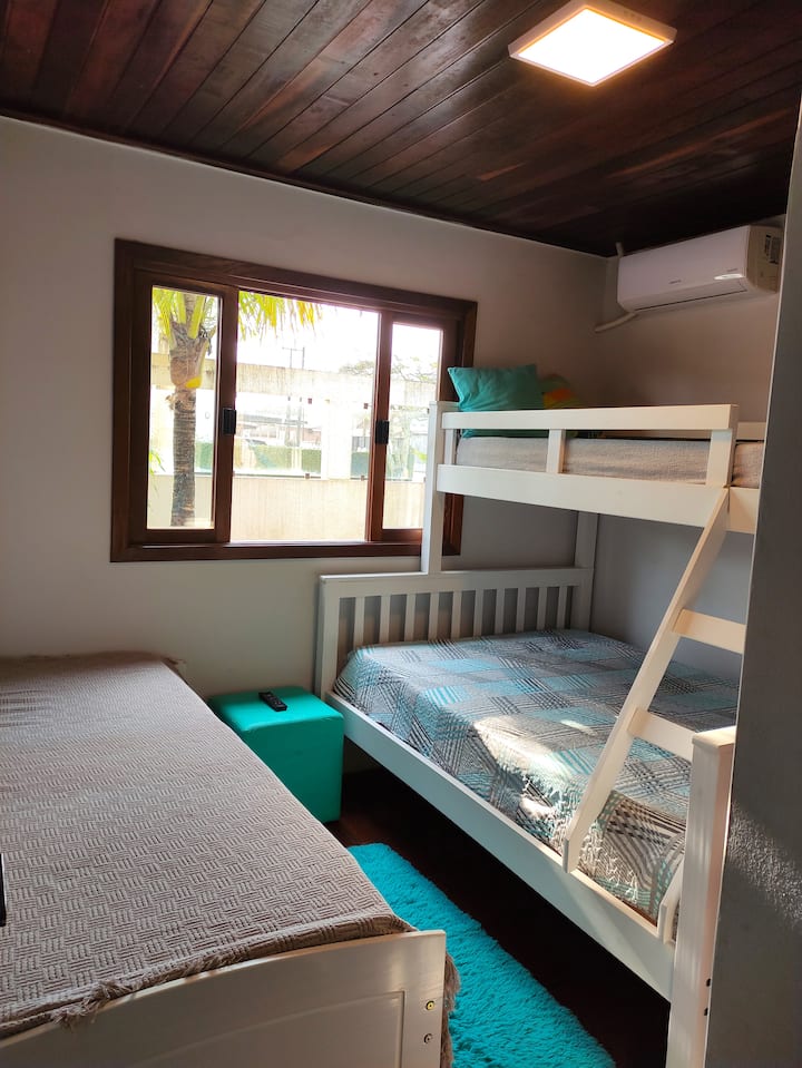 Dormitorio 03: tres camas individuales, TV y aire acondicionado.