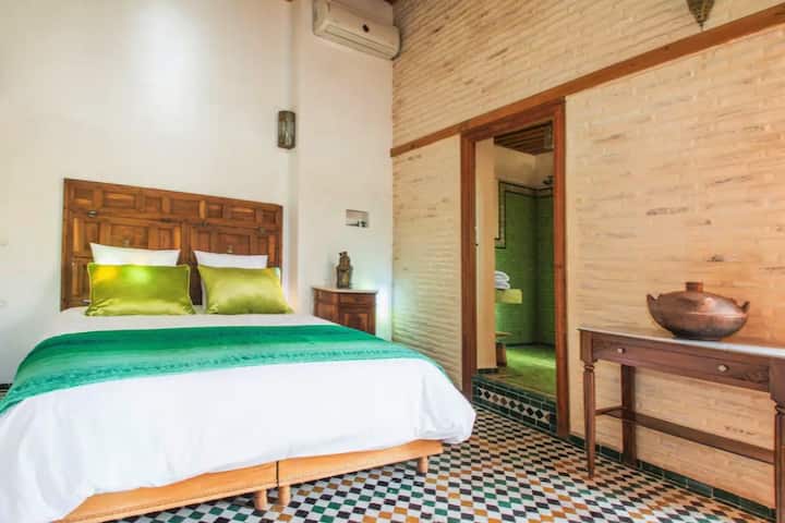 Chambre verte du dernier niveau ouvrant sur la terrasse avec sa salle de bain privative.
