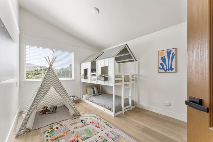 The kids bedroom has a twin size bunk bed, play mat, toys, games, and closet space