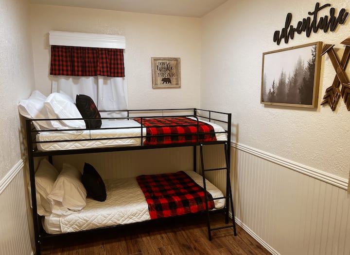 Spavaća soba 2 s bračnim krevetima na kat i malim radnim stolom.  Ima ormar s stalkom za prtljagu te dodatnim plahtama i dekama