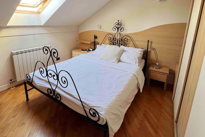 Chumba cha kulala kilicho na kabati lenye mabawa matatu, kabati la kujipambia na dawati.