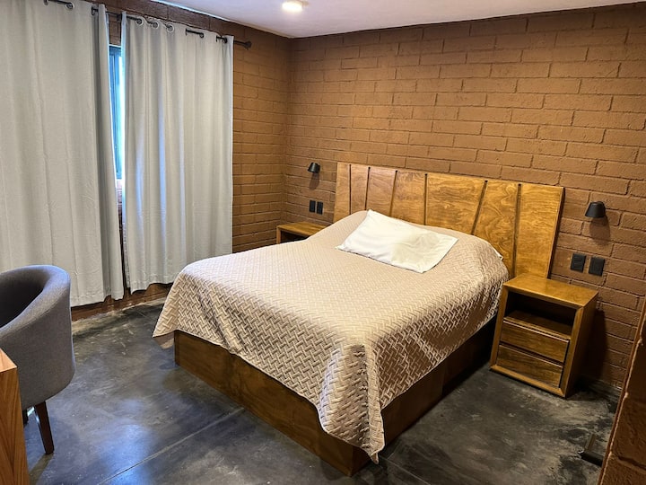 Стая с двойно легло, работна маса и плосък екран, за да се свържете с акаунта си в Netflix.