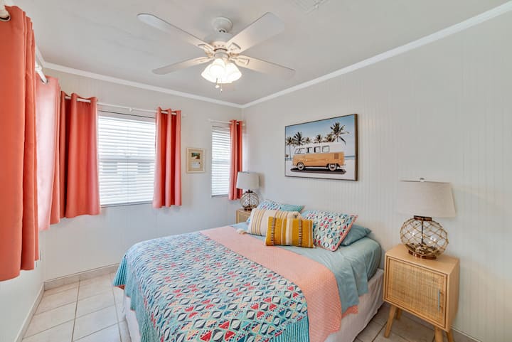 Welcome to the 'Coral Room': A queen bed, dresser & makeup station in the closet, dual nightstands, ample natural light, and our beachy vintage VW bus art setting a coastal mood.