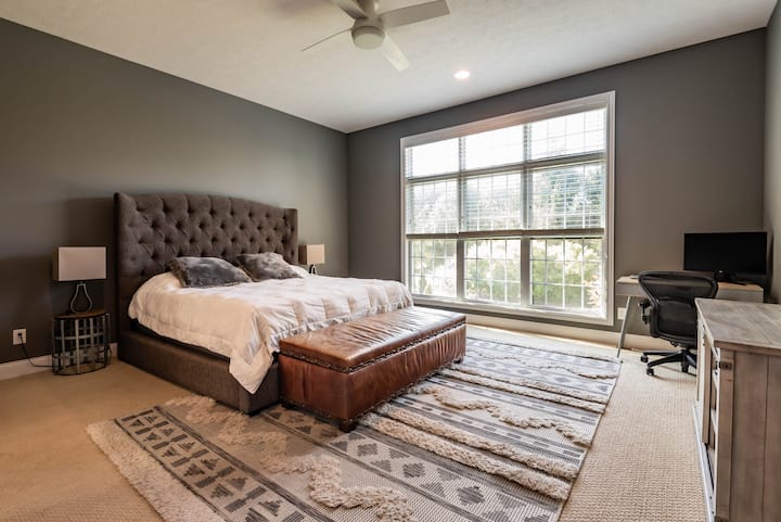 Master bedroom with King Bed and mounted TV. Working Desk with monitor. Beautiful view looking over the backyard