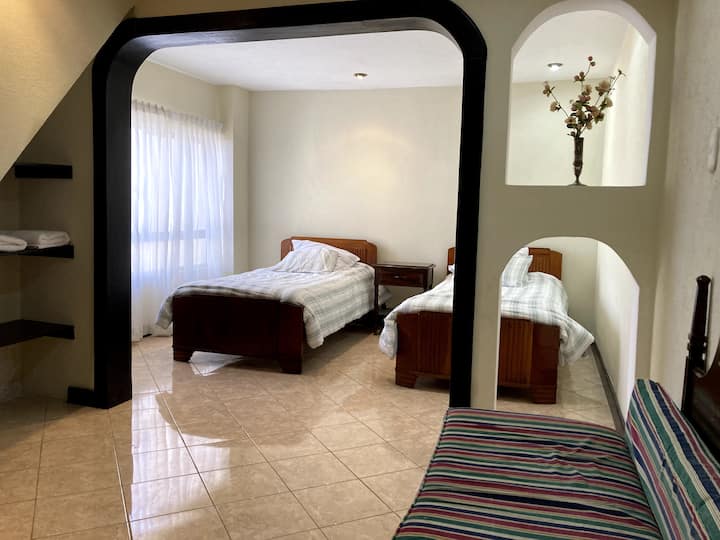 Chumba cha kulala chenye vitanda viwili pacha na kitanda cha sofa