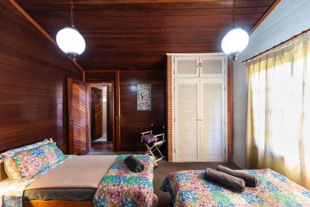 Habitación con una cama doble y dos camas individuales y armario.