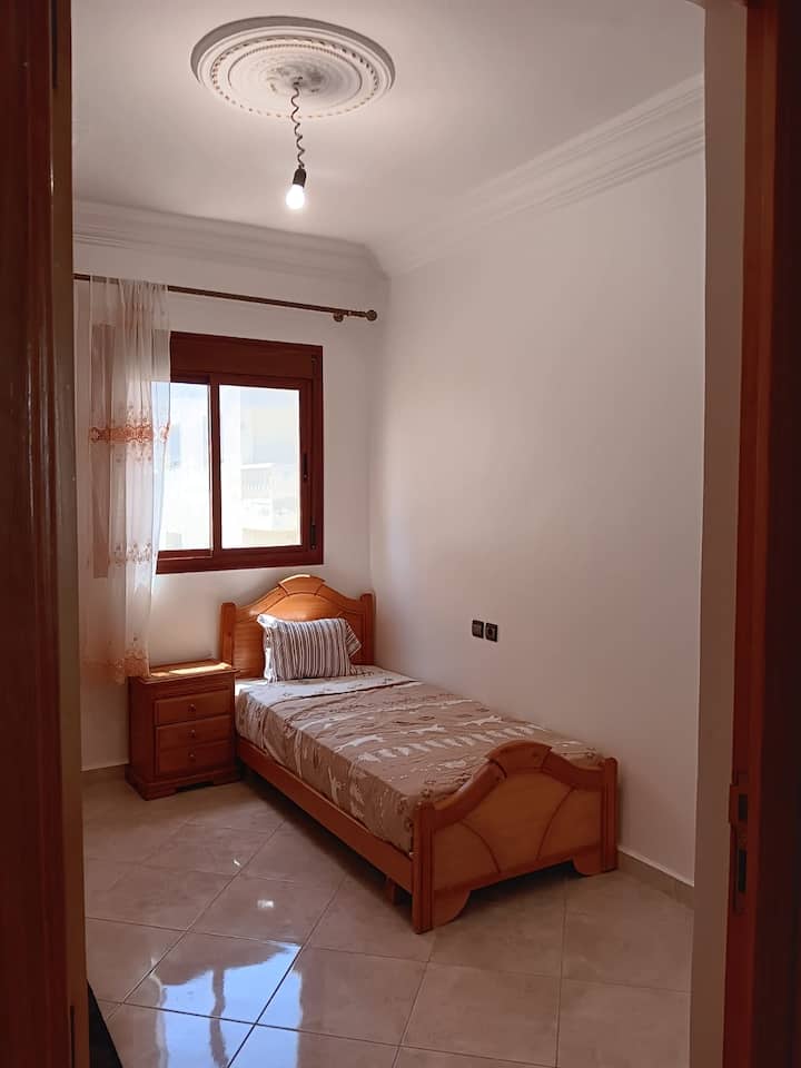 Zweites Schlafzimmer mit zwei Einzelbetten, abdunkelnden Jalousien und einem Kleiderschrank. 