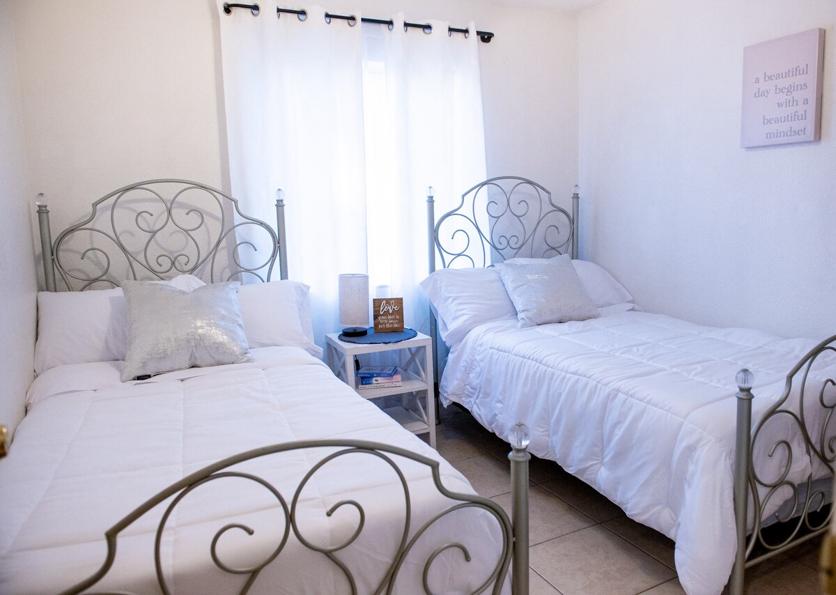 Este dormitorio luminoso y alegre cuenta con dos acogedoras camas individuales, muebles blancos y una gran ventana que llena el espacio de luz natural, creando un refugio fresco y cómodo ideal para niños o amigos.


