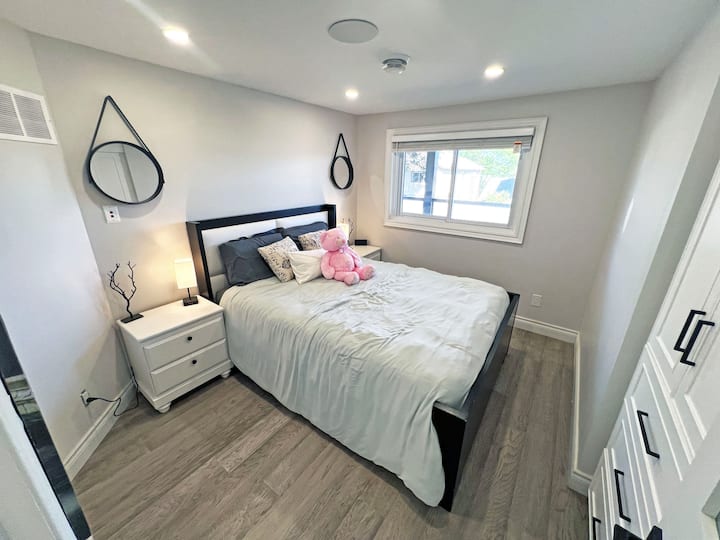 Upstairs Bedroom 2 features a cozy queen-size Tempurpedic bed, offering a restful retreat. The inviting space is perfect for unwinding after a long day, ensuring comfort and a peaceful night's sleep.