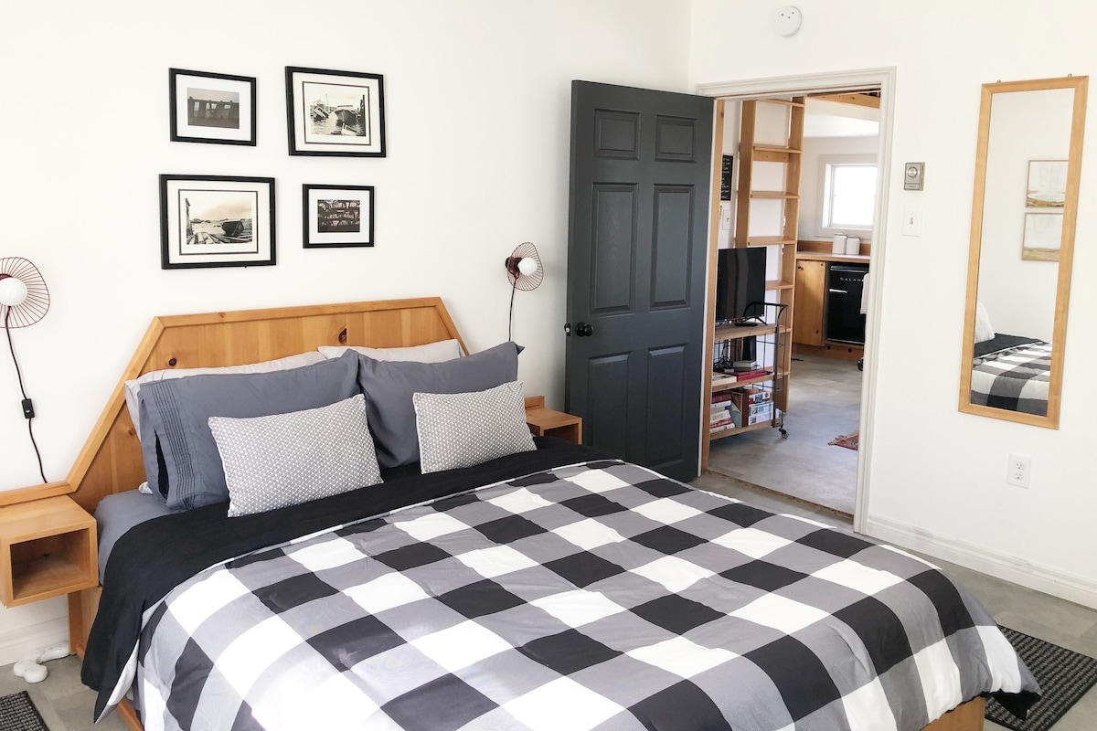 Private bedroom with queen bed and chest of drawers.