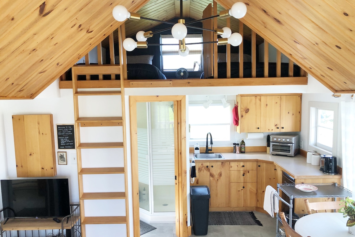 Sleeping loft over kitchen and washroom with ladder  hook to tuck away when not needed.  Loft with safety gate.