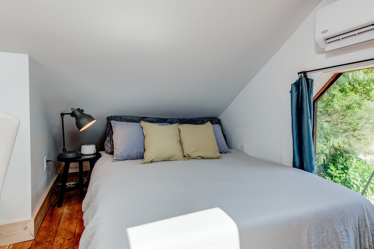 Sleep under the stars! The loft offers a queen-sized bed and a skylight view of the Blue Ridge Mountains. (Note: The charming, peaked ceiling is best suited for guests who aren't exceptionally tall!