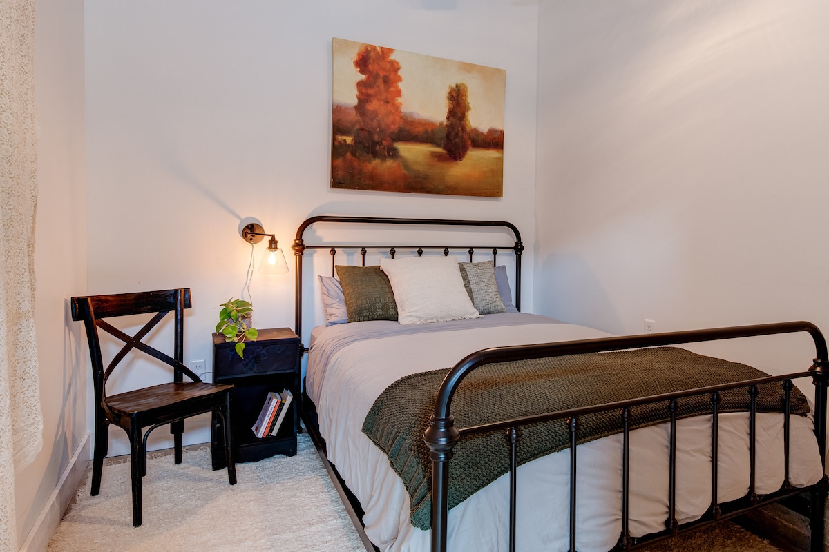  Retreat to the cozy bedroom featuring a comfy Queen bed for a great night's sleep. Enjoy modern comfort with a sound machine and mini-split climate control, all surrounded by the unique character of the original barn door and wall.
