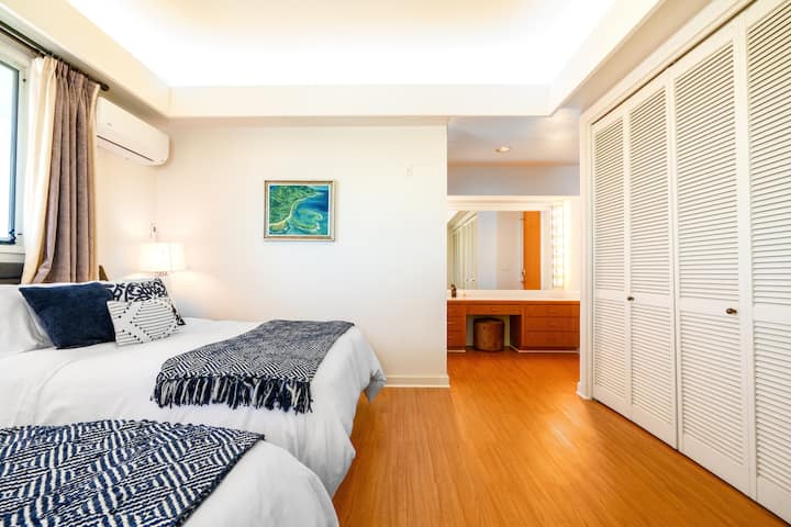 Habitación Maui: dormitorio con vistas al océano a lo lejos, colchón eléctrico con camas ajustables tamaño queen, aire acondicionado fuerte y baño privado (arriba).