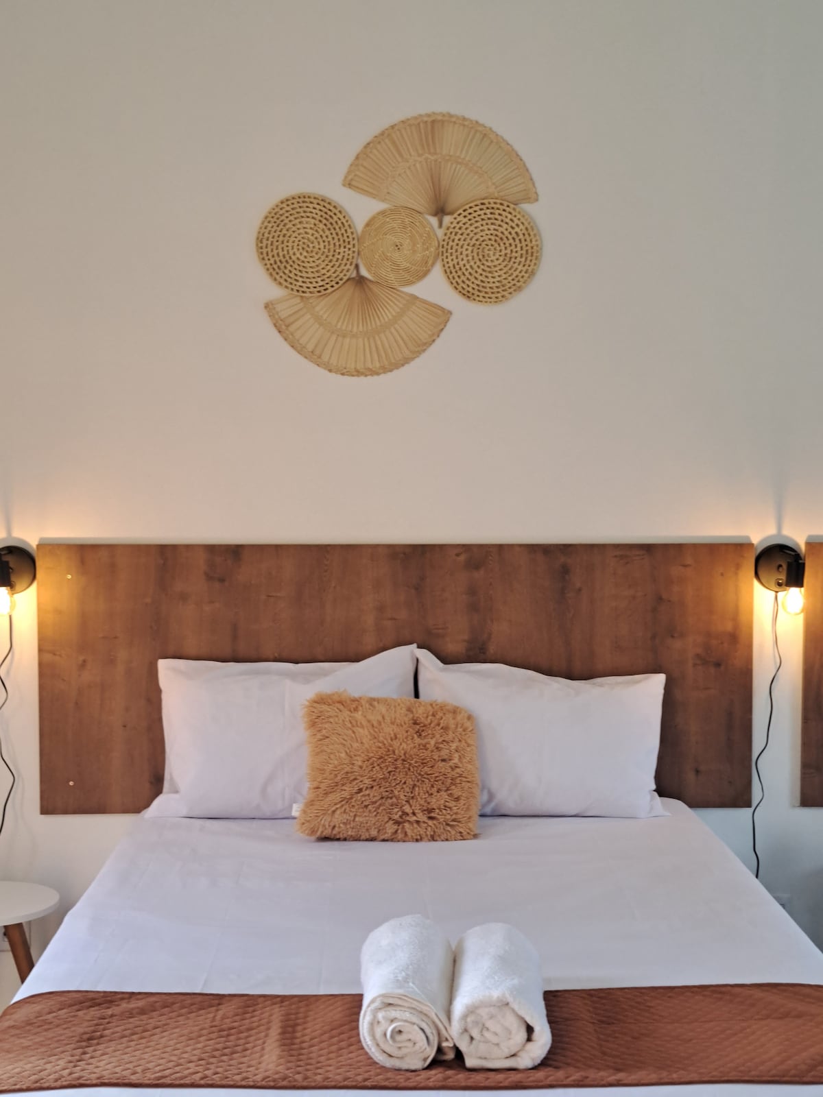 Double bed, decor details, lamp and towels.