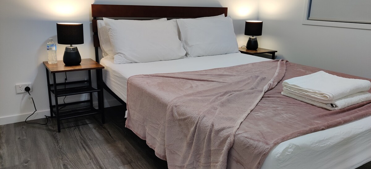 Пространа брачна спална соба 1 со вградени наметки и тавански вентилатор.