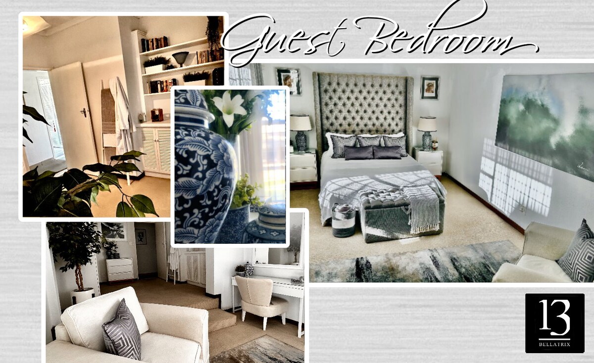 The guest bedroom features a spacious bed with a tufted headboard, flanked by soft lighting. A soft area rug lies beneath. Seating is provided by light-colored armchairs, and decorative elements, including a floral arrangement and an ornate vase, adorn the side tables.