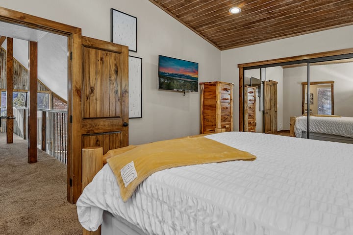 Experience luxury in our upstairs primary suite, featuring a smart TV for your entertainment. This spacious and well-appointed room offers a modern retreat with top-notch amenities, ensuring a relaxing stay.