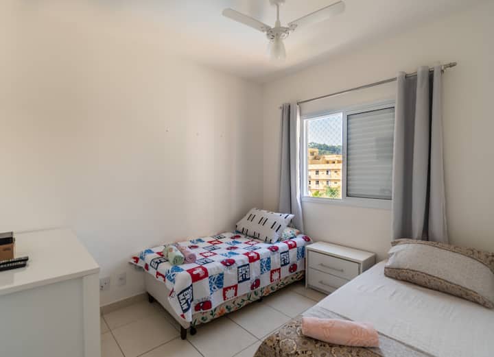 Единична стая с две единични легла, вентилатор на тавана и скрин.