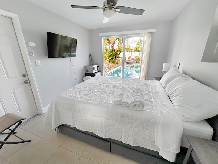 ห้องนอนที่มีเตียงควีนไซส์และทีวี