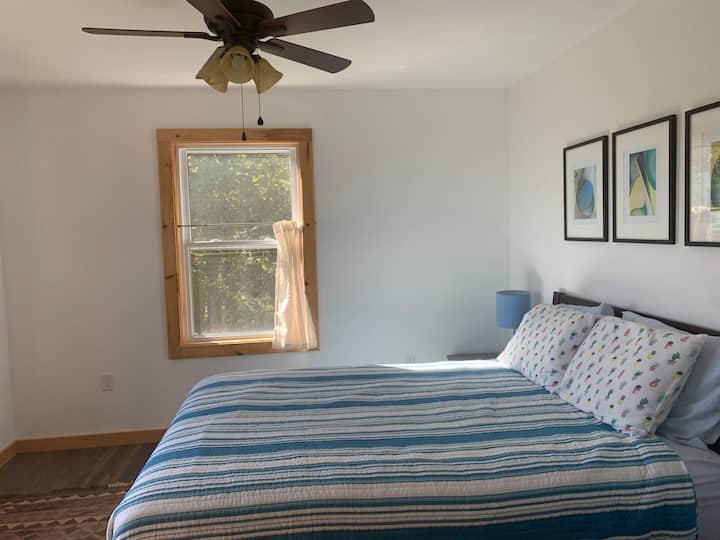 Bright and cheery Bedroom 1, with queen bed and a mountain view.