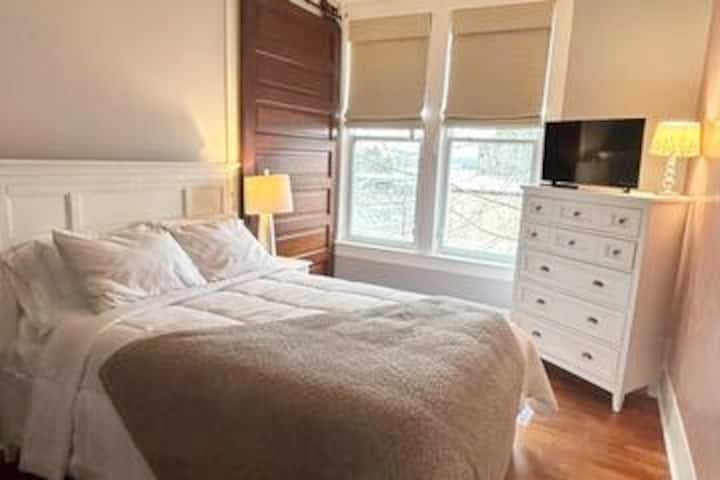 Spavaća soba za goste 1 ima bračni krevet, visoke stropove i rolete za zamračivanje.