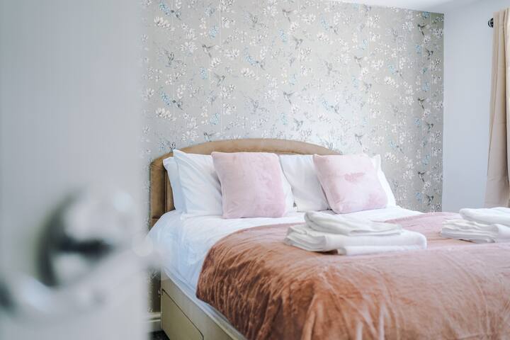 Elegante dormitorio doble con detalles en rosa suave y una sensación acogedora y atractiva.