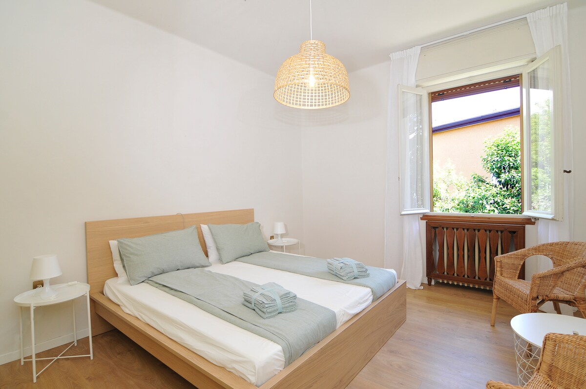 Primer dormitorio con una cama doble, armario, dos mesitas de noche, mesa de centro y dos sillones.