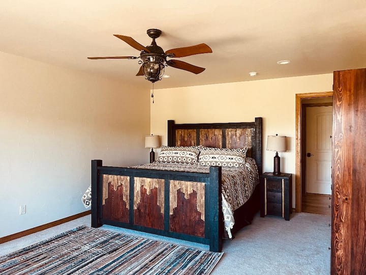 חדר שינה ראשי עם מיטת קינג וחדר רחצה צמוד.