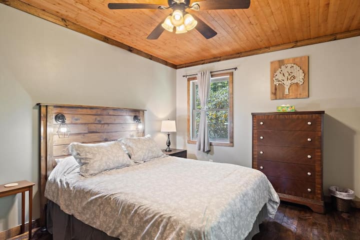 Upstairs queen bedroom, complete with windows for natural light, ceiling fan, electric baseboard heat, and dresser/closet storage. 