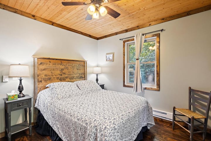 Upstairs full bedroom with closet and dresser storage, ceiling fan, baseboard electric heat, and natural light.