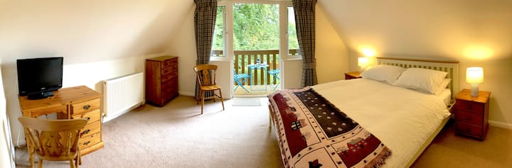 Master bedroom with king size bed, balcony with views over the grounds, built in wardrobe, full length mirror, chest of drawers, desk, 2 chairs and TV with DVD player and still plenty of room for a travel cot (one available.)