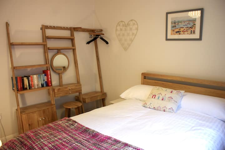 Bedroom 4 on the ground floor with 4 foot double bed, bedside tables, hanging rail, dressing table with mirror and stool, various other drawers and shelves. A selection of popular books to read. 