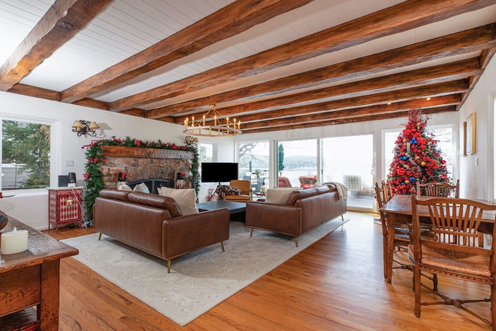 Panoramic lake views meet modern fireside luxury. Relax by the grand red rock fireplace amidst custom wood beams and leather comfort. Vintage charm in every detail.